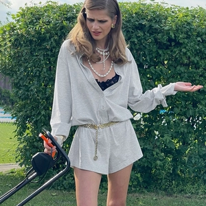 Detail view of light grey knit loungewear set with buttoned top and elastic waist shorts