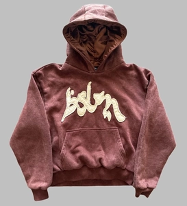 Detail eines burgunderfarbenen Hoodies mit Satinfutter und weißer Stickerei