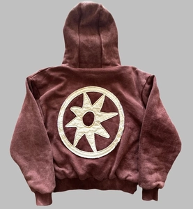 Nahaufnahme der übergroßen Sternen-Stickerei auf der Rückseite eines braunen Hoodies