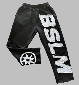 Detailansicht von BSLM-Patch und Sternstickerei auf schwarzer Streetwear-Hose