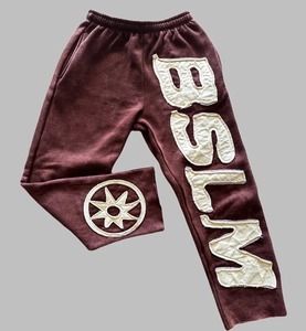 Detailansicht der burgunderroten Jogginghose im High-Street-Stil mit weißer BSLM-Stickerei