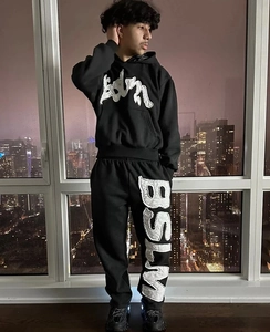 Detail der weißen Handtuch-Stickerei auf dem schwarzen Streetwear-Hoodie und Jogginghose