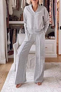 Detail view of grey V-neck long sleeve top and wide leg trousers set with front seam detail