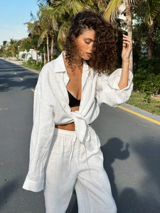 Detail view of white linen two-piece set featuring long-sleeve shirt and wide-leg drawstring pants