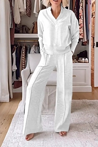 Detail view of white V-neck long sleeve top and wide-leg trousers in soft knitted fabric