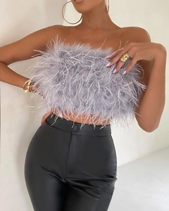 Dettaglio del top a fascia con piume grigie abbinato a pantaloni in pelle nera chic