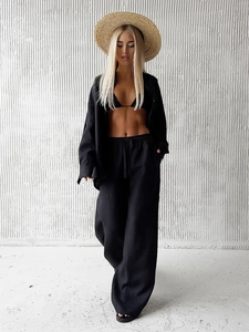 Detailed texture of black linen three-piece set with loose shirt and wide-leg trousers