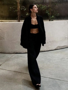 Detailed outdoor shot of black linen three-piece set with vest, shirt and wide-leg pants