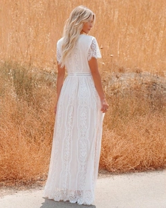 Detail of bohemian white lace maxi dress with high waist design and full floral embroidery