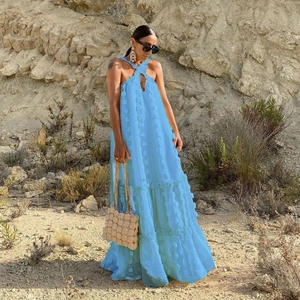 Detail of light blue tiered halter dress featuring 3D floral appliques and mesh fabric