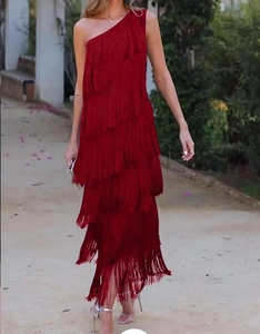 Detail of red tiered fringe layers on a one-shoulder evening gown for a dynamic motion look