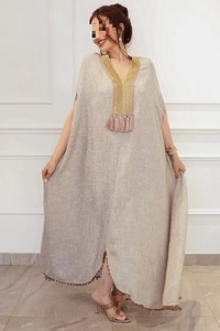 Robe caftan en lin avec broderie dorée et détails de pompons roses au décolleté