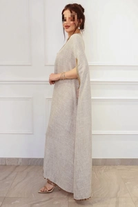 Détails d'un caftan en lin élégant avec poignets brodés d'or et ourlet à glands