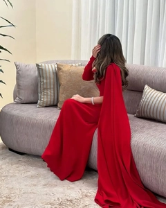 Detail van een rode avondjurk met elegante cape-mouw en een slank silhouet