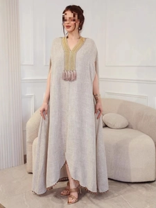 Robe longue en lin beige avec col en V, broderie dorée géométrique et détails à glands