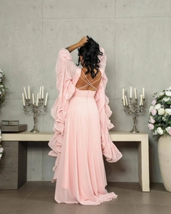Detail of light pink evening gown featuring tiered ruffle sleeves and a crisscross back