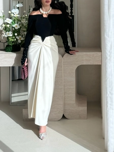 Detail van elegante jurk met witte parels bij de manchetten en geplooide satijnen rok