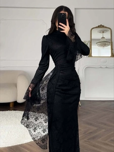 Close-up of elegant black lace dress with long sleeves and detailed floral embroidery