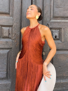Detail of rust red halter dress with fine pleats and tassel texture for party wear