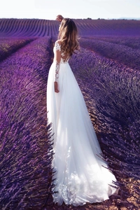 Robe de mariée élégante en dentelle à manches longues avec jupe en mousseline en plein champ