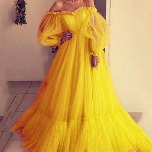 Detail of off-shoulder yellow mesh gown with puff sleeves and bow waistband accent