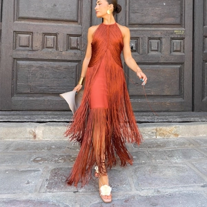 Elegant rust-colored halter neck maxi dress with dynamic long tassels and layered fringe hem