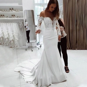 Detailed view of the elegant lace bodice and long sleeves of the white mermaid wedding gown