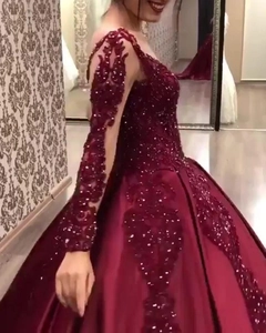 Elegant wine red evening gown featuring lace appliques and a full satin floor length skirt