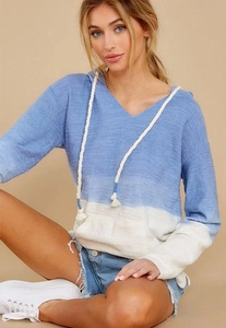 Detail of blue and white ombré knit hoodie featuring a deep V-neck and woven drawstrings