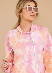 Detail of pink and orange tie-dye cropped hoodie with white drawstrings and soft texture
