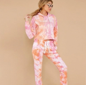 Close-up of pink and orange tie-dye loungewear set featuring white drawstrings and knit fabric