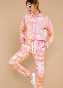 Detail of soft pink tie-dye lounge set featuring hooded short sweatshirt and drawstring pants