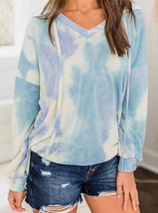 Detail of a casual long-sleeve tie-dye hoodie paired with distressed denim shorts