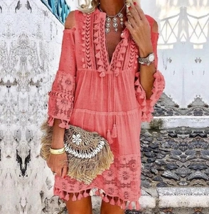 Détail d'une robe bohème corail avec dentelle, broderie complexe et finitions à franges
