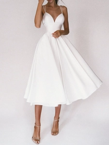 Détail de la robe en satin blanc élégante avec col en V et de fines bretelles spaghetti