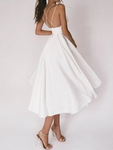 Détails d'une robe midi en satin blanc avec fines bretelles et dos croisé à lacets