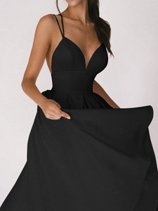 Détail d'une robe longue noire à décolleté en V plongeant avec jupe évasée et fines bretelles