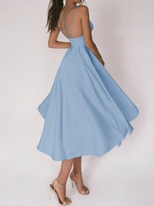 Détail d'une robe dos nu bleu clair avec bretelles croisées élégantes et ourlet évasé