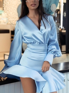 Détail de la robe en satin bleu clair avec manches lanterne et ourlet élégant à volants