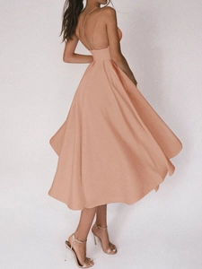 Détail du dos croisé d'une robe midi en satin pêche avec une jupe évasée