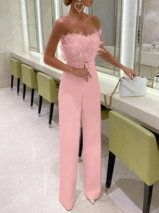 Pink strapless wide-leg jumpsuit with faux feather trim and matching waist belt