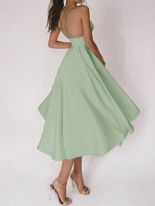 Détail d'une robe mi-longue dos nu vert sauge avec bretelles croisées et jupe évasée en A