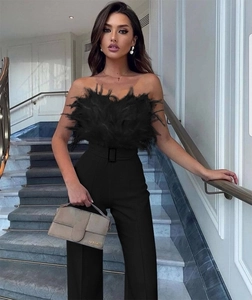 Detail of elegant black feather bandeau top paired with high-waisted tailored trousers
