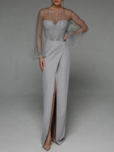Detail of light gray evening dress featuring pearl embellishments and high slit