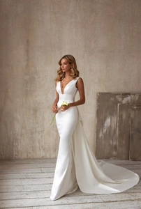 Détail de robe de mariée en satin blanc avec col en V profond et traîne élégante
