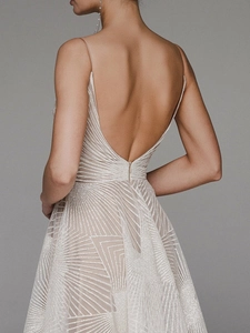 Détail de robe de soirée dos nu à paillettes avec motifs géométriques et fini argenté
