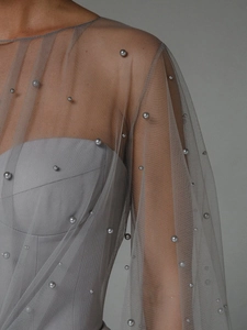 Detail of grey tube dress featuring delicate mesh fabric and scattered pearl embellishments