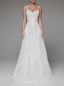 Detail of white A-line maxi dress featuring intricate sequin embroidery and slim straps