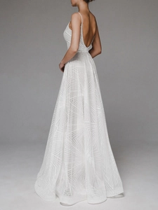 Detail of white sequin maxi dress featuring open back design and geometric patterns