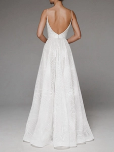 Detail of white backless dress featuring geometric radial embroidery and thin straps